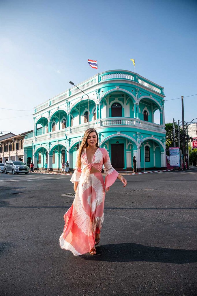 Melissa crossing the street with an old peranakan house in Phuket Thailand