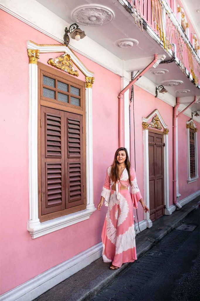 Melissa in Phuket Old Town wearing a pink dress in front of a pink house