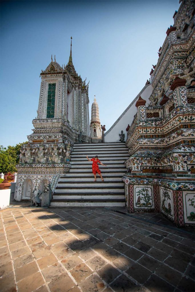 Melissa sitting on the stairs of one of the sides of Wat Arun Temple in Bangkok