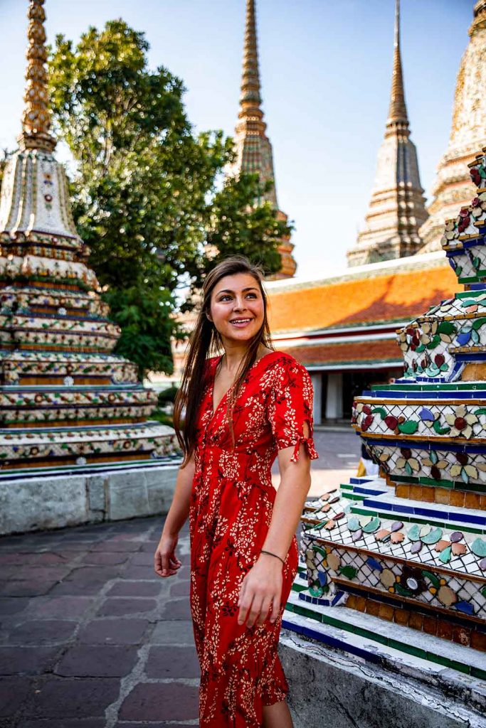 portrait of girl around the world in between two spires at wat pho