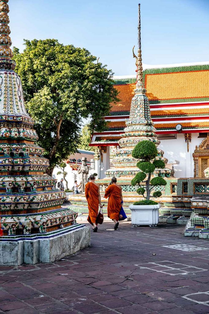 monks walking through wat pho towards the main temple