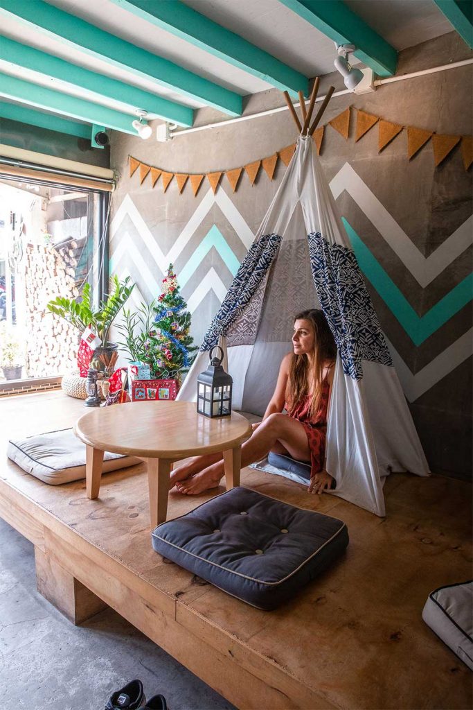 Melissa sitting inside a tipi tent inside a cafe overlooking phuket old town streets
