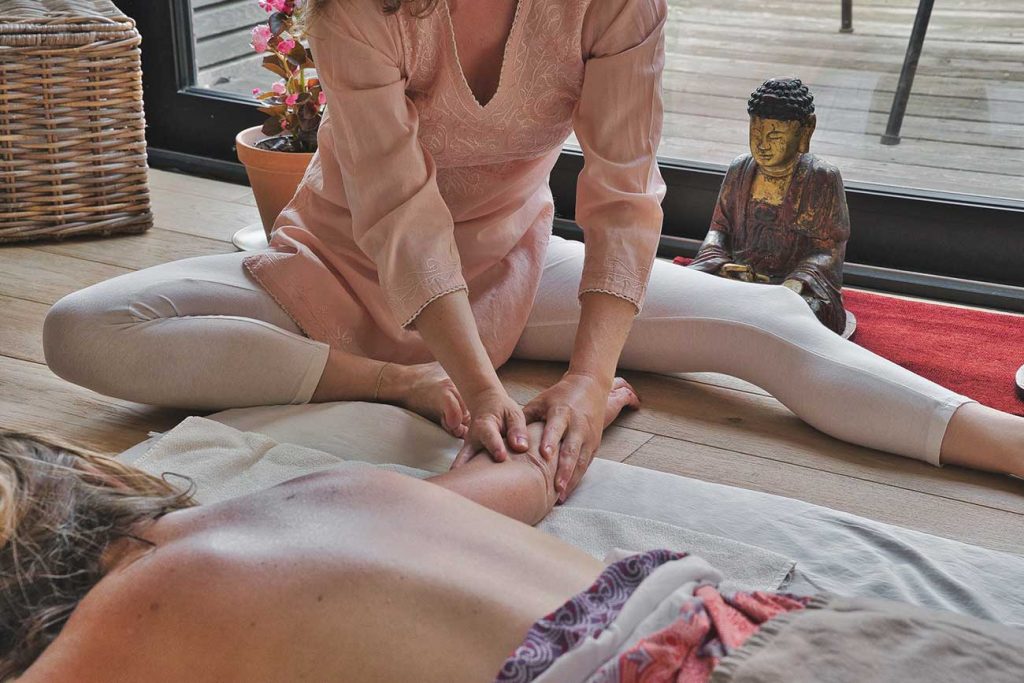 person giving a thai massage to a lied down person