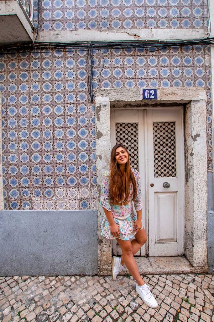 Melissa poses against the tiled walls of the houses in the streets of Lisbon