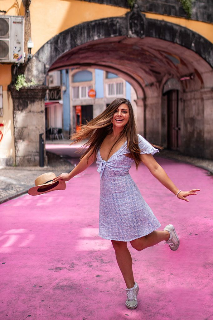 Melissa twirls happily on the pink street in lisbon portugal