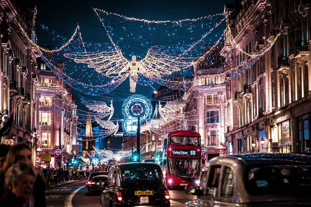 Street in London with people and Christmas angels hanged above the streets