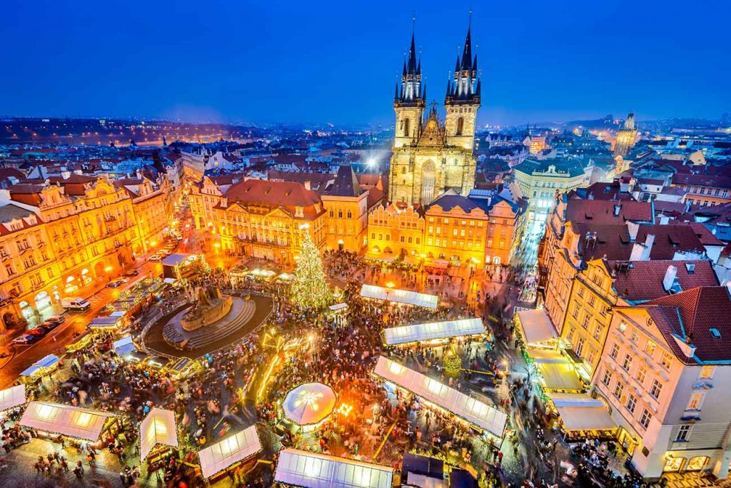 Prague's center square seen from above with thousands of people walking on the streets at night