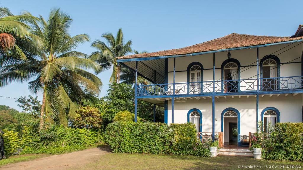 Main house next to tall palm trees at Roça São João dos Angolares in Sao Tome