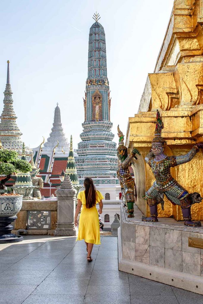 Melissa walking down a walkway leading into a spire in The Grand Palace Bangkok