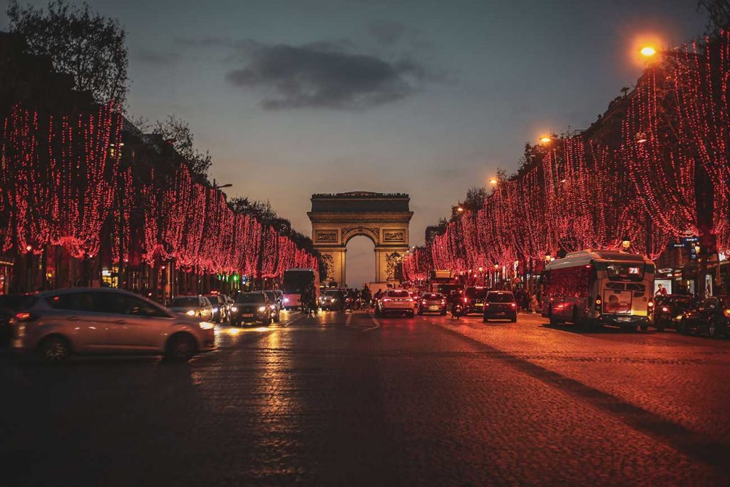 Street Leading to arc de triomphe in Paris with cars driving past it
