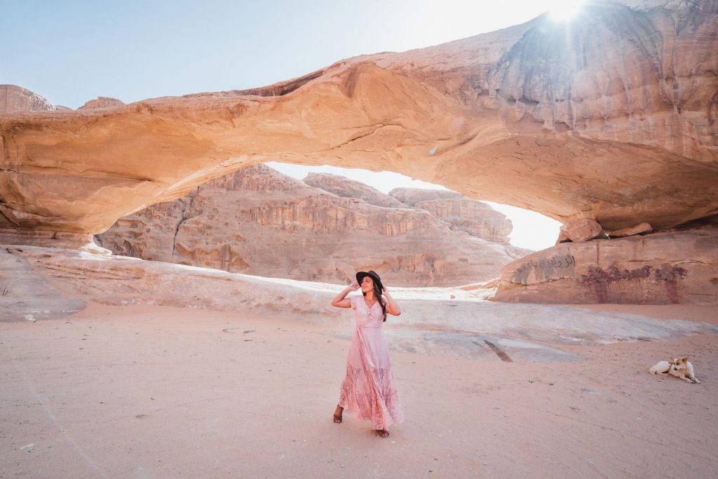 Melissa stands in front of a small rock bridge in the Wadi Rum desert.