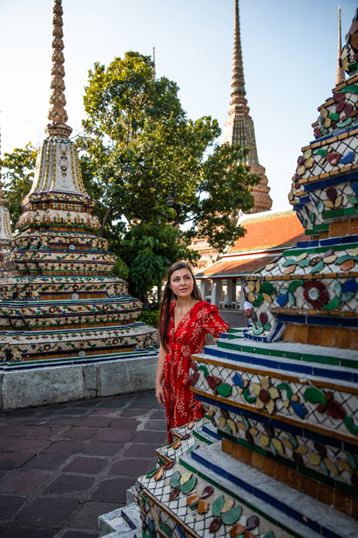 Melissa walking between the colourful spires of Wat Pho temple