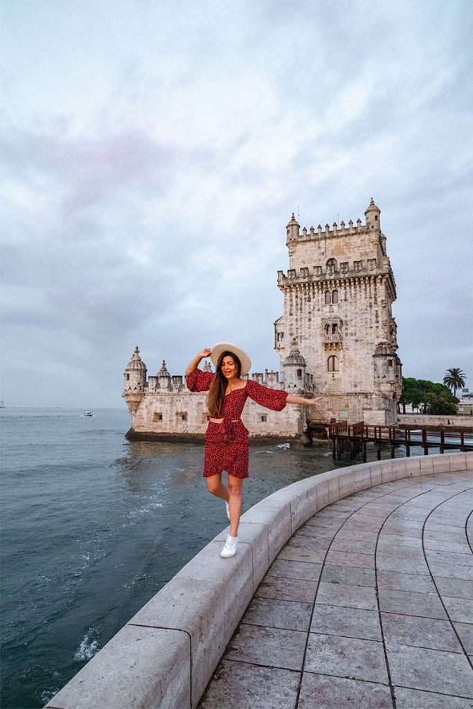 Melissa balances on a low wall outside Belem Tower in Lisbon Portugal