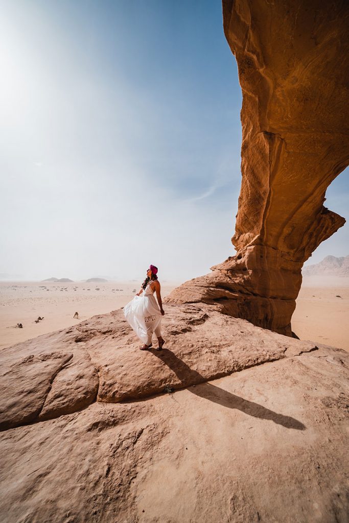 Melissa standing under the rock bridge on the Wadi Rum Desert