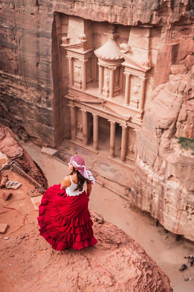 Melissa standing on the edge of a cliff overlooking the Treasury in Petra Jordan