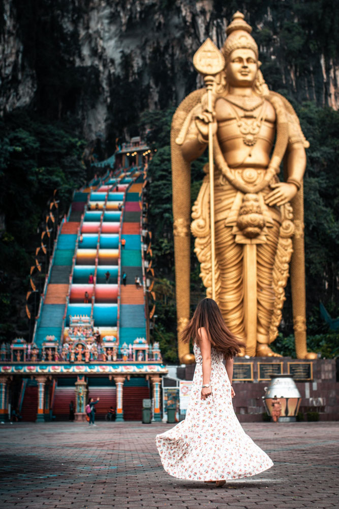 Melissa swishes her skirt at the entrance to the rainbow steps of the Batu Caves in Malaysia.