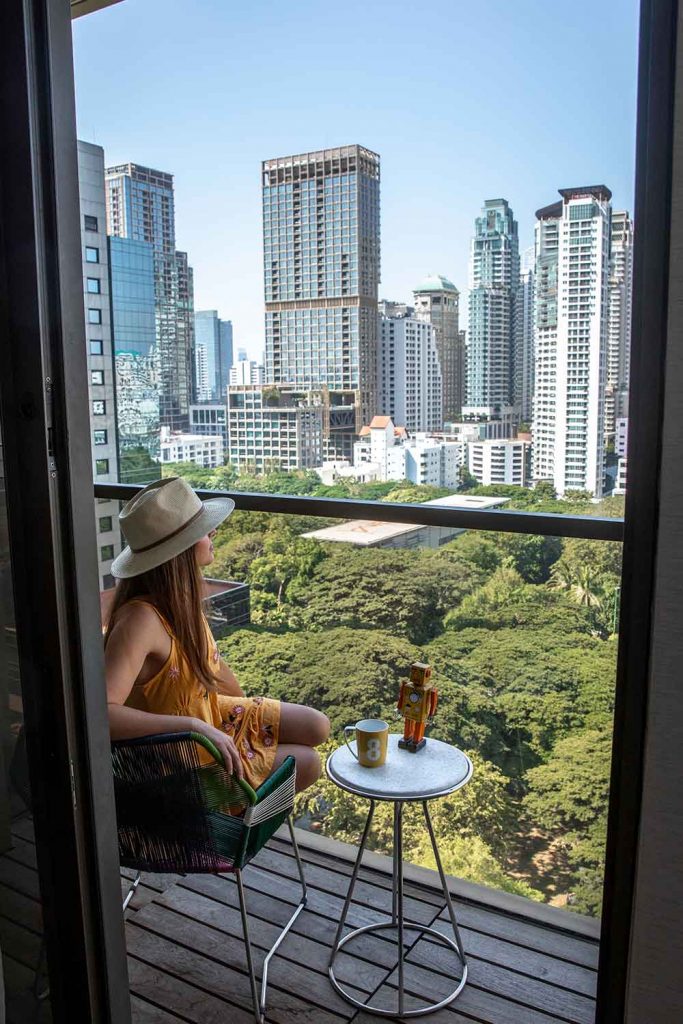 Girl Around the World sitting on the balcony facing the park at Hotel Indigo Bangkok